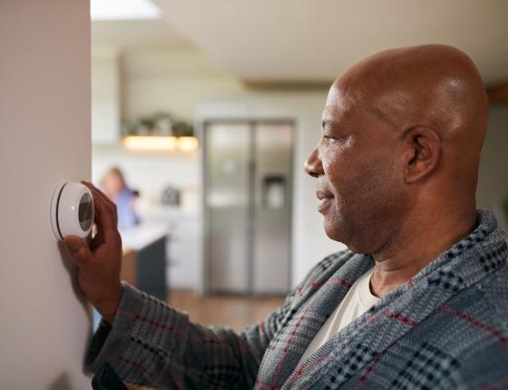 man adjusting thermostat