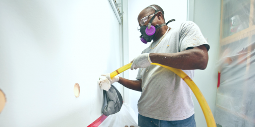 man installing wall insulation